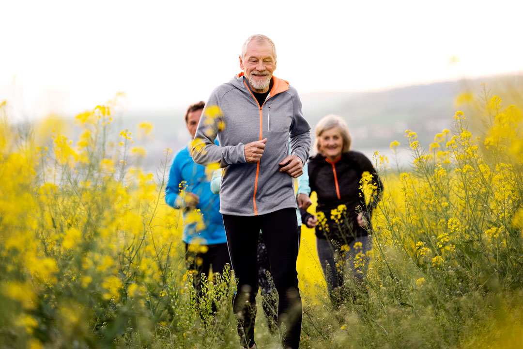 Healthy, senior man running with group of friends